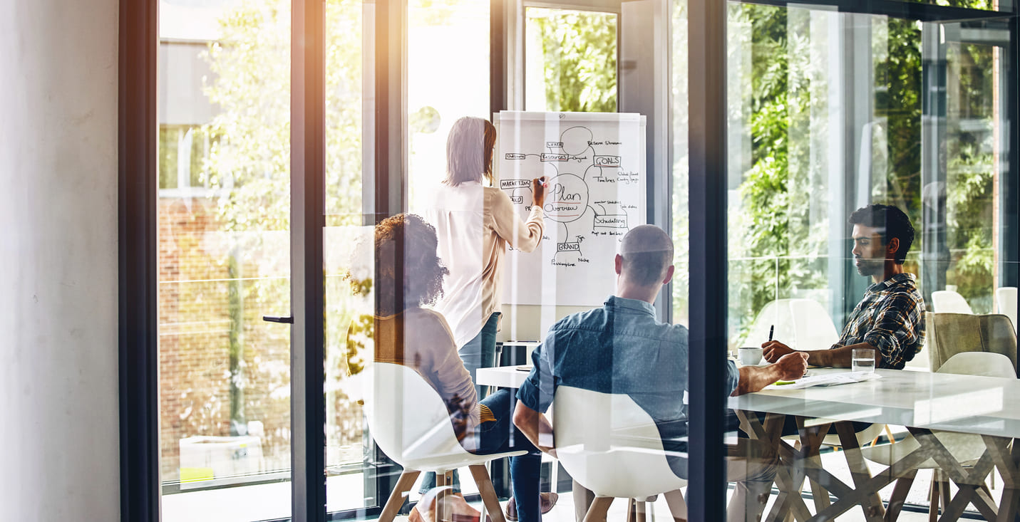 Gruppe Menschen beim Workshop hinter Glaswand