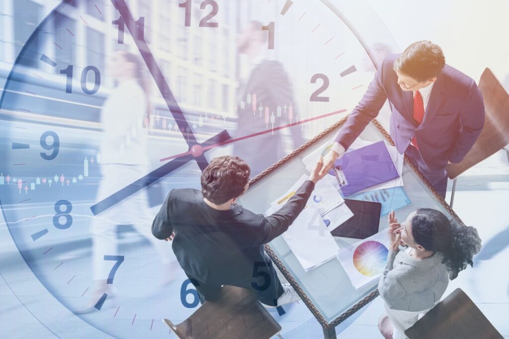 Meeting mit drei Personen überlagert mit einer Uhr